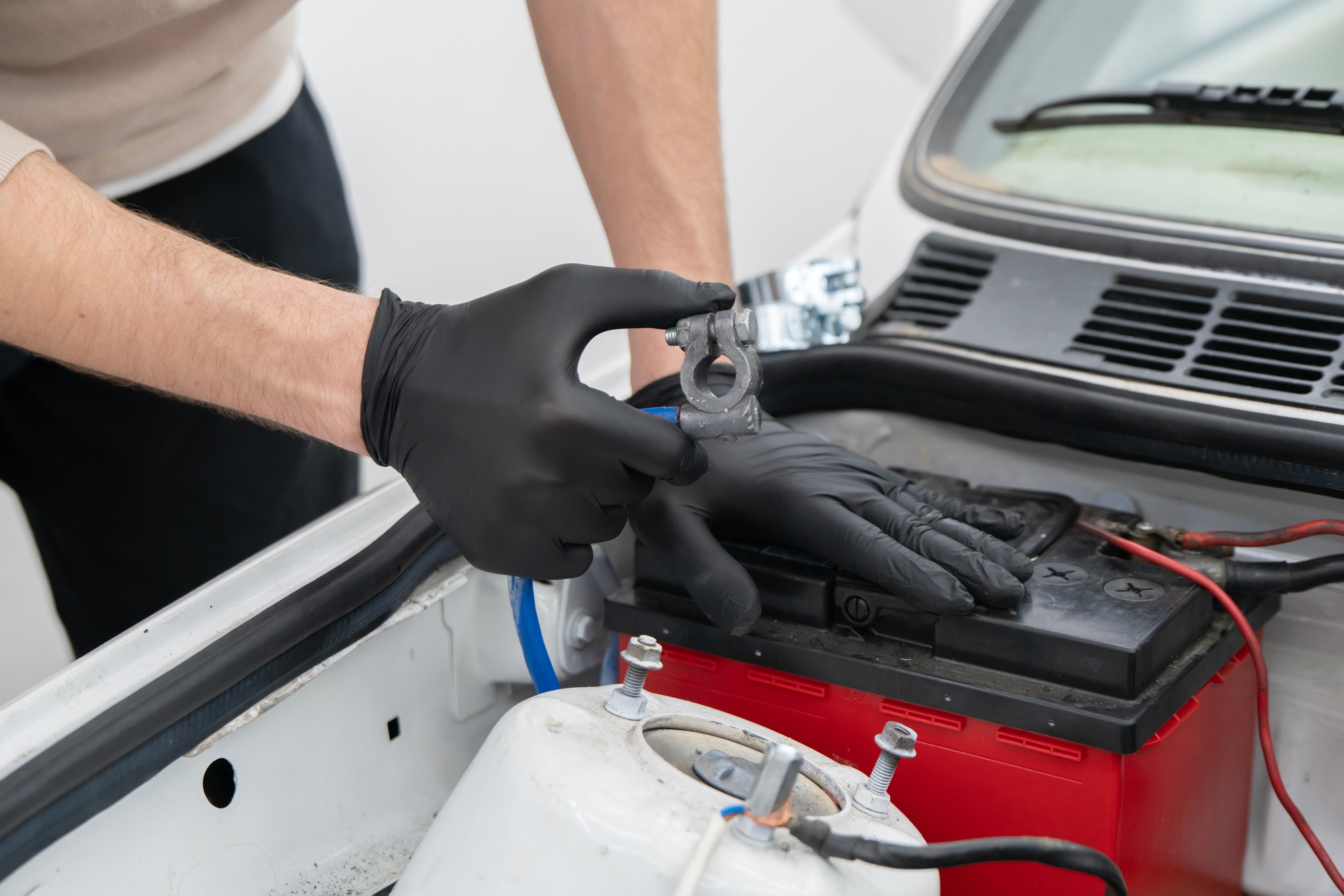 A skilled mechanic inspects the battery terminal